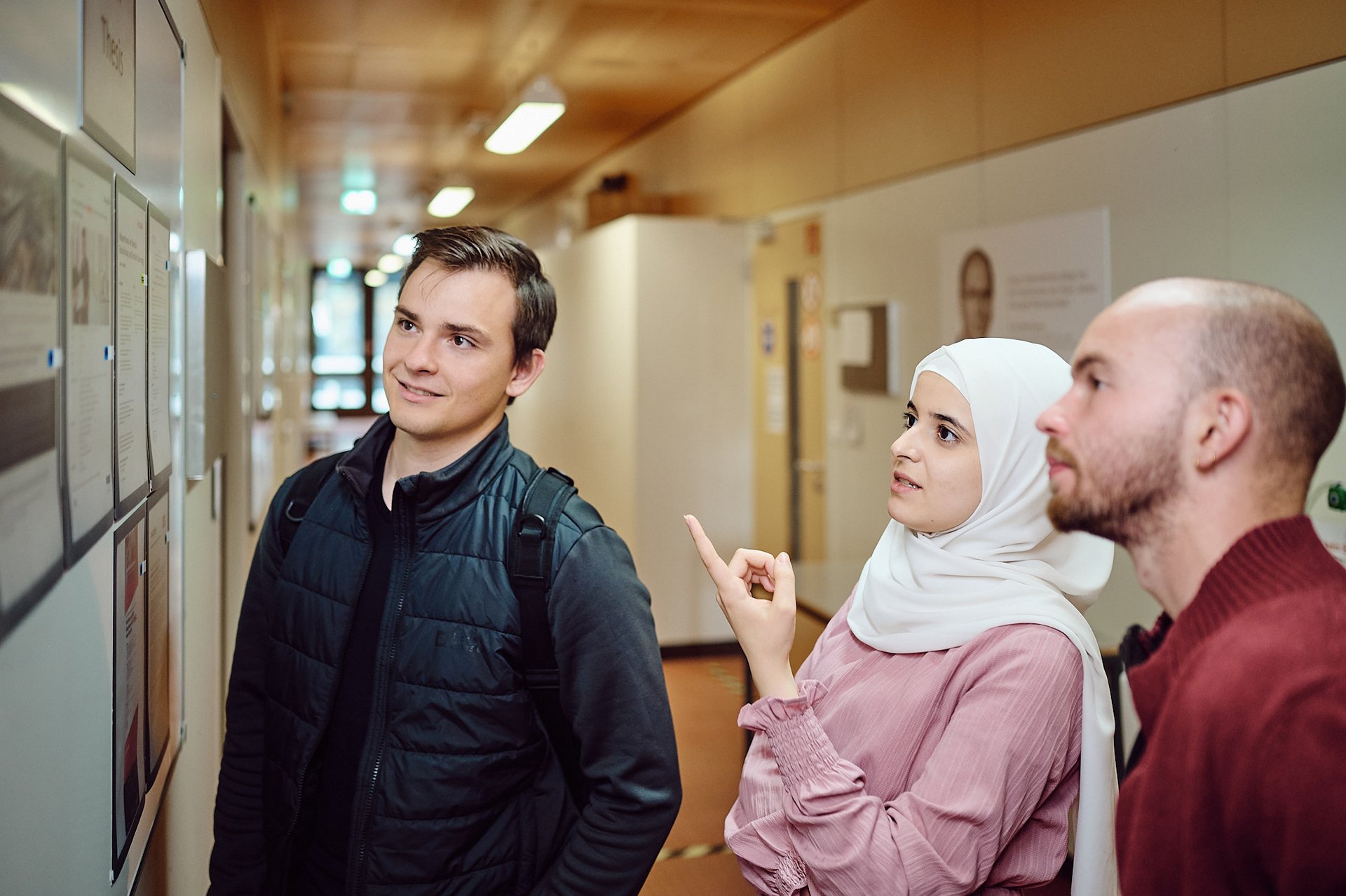 Studierende informieren sich am Schwarzen Brett über Stellenausschreibungen