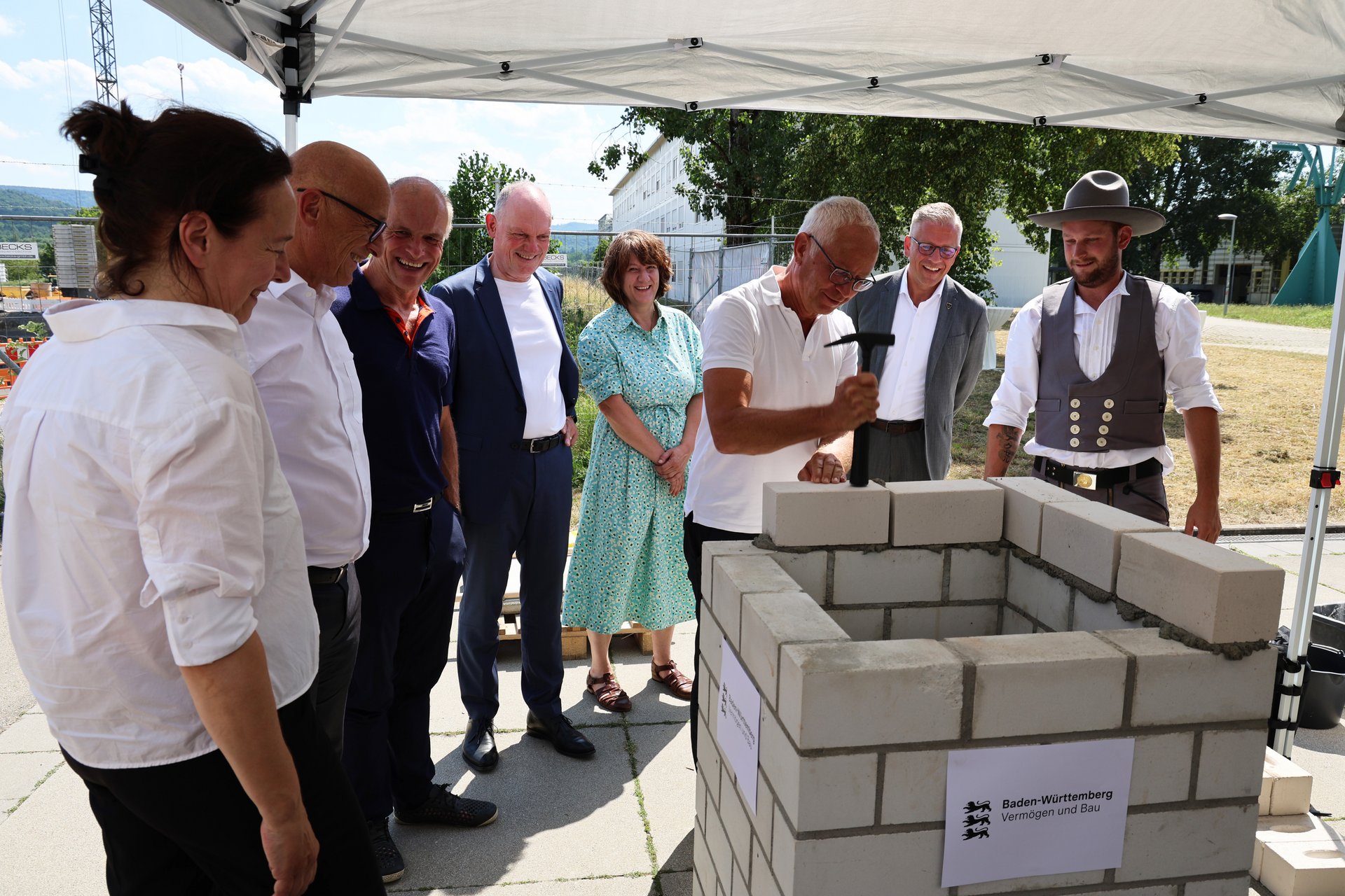 Herr Leisner klopft den Stein fest.